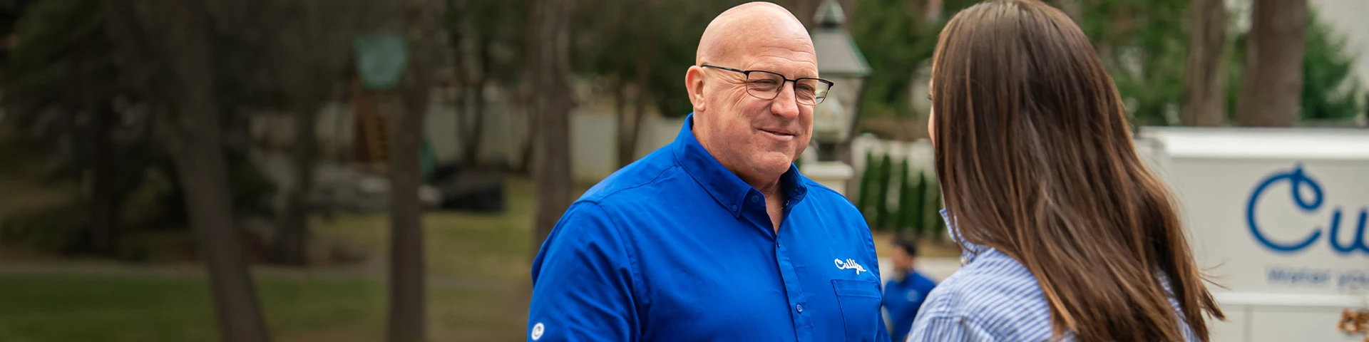 Service medewerker in blauw Culligan-uniform schudt hand met klant